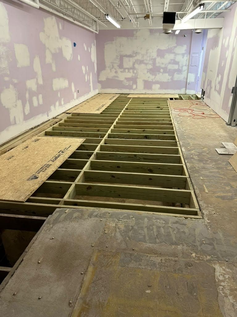 New pressure-treated floor joists installed across a large room