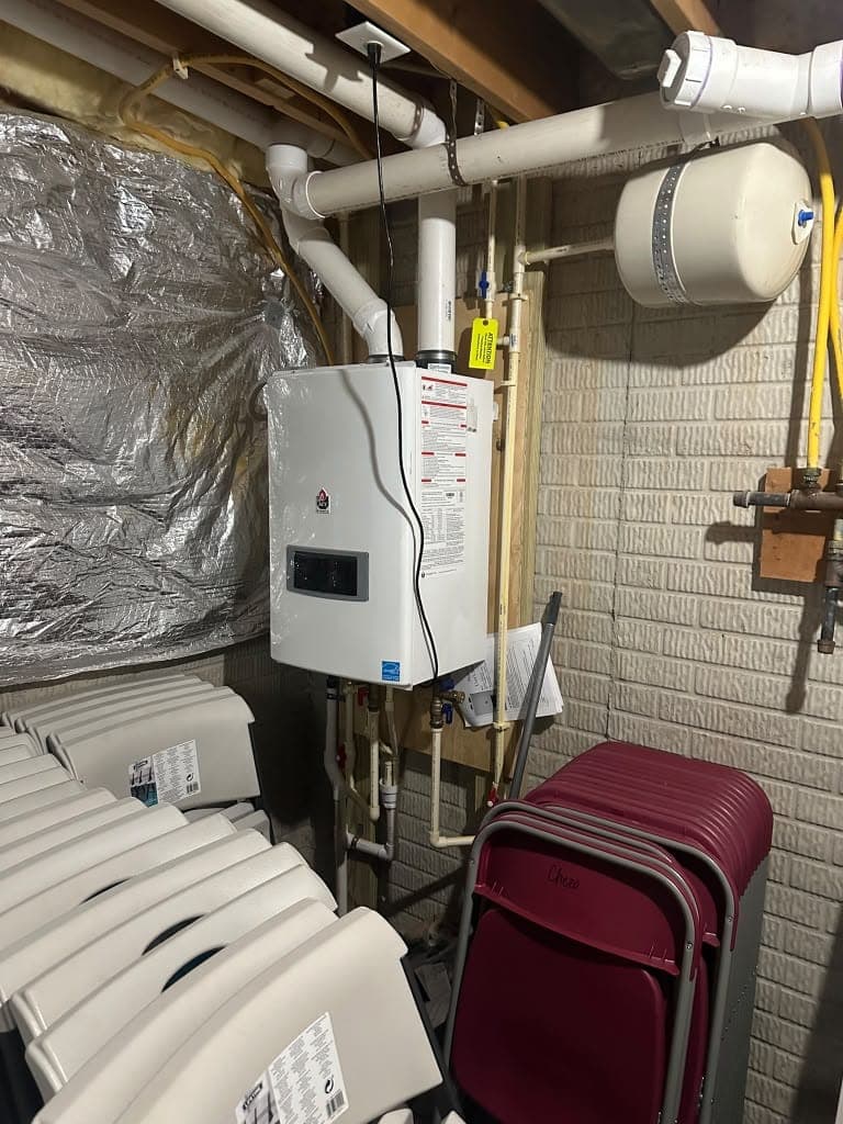 Wall-mounted tankless water heater with PVC venting in a basement