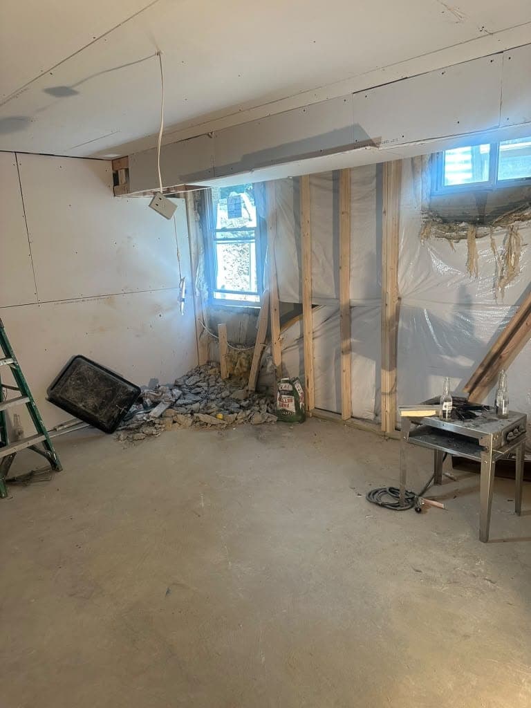 Unfinished basement with new wall framing in progress